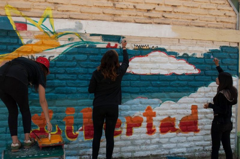 Estudiantes beneficiarios del programa Actuar a Tiempo pintan mural en su colegio